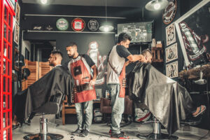 barbers cutting clients' hair in a shop