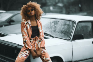 successful looking woman leaning against car